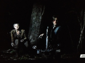 Daryl silently springs up to standing, motions Carol back as he goes forward to investigate...