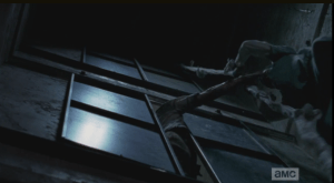 As Noah lowers hinself down, he gets grabbed by a walker...