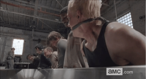 As the camera pans down the long line of bound, kneeling men, we see