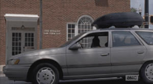 We see Carol pull up in front of a law office building that looks secure, windows intact.