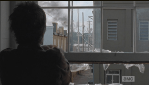 The next day, as Carol assembles a rain catcher out the window, she sees a black plume of smoke in the horizon...it is coming from the direction of the prison. After a moment's hesitation, Carol rushes out of the office...