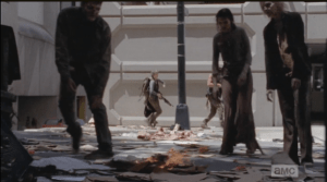 As the walkers lurch over to the flame, Daryl and Carol sneak past them, into a parking garage, where Daryl easily takes down a stray walker. Otherwise, all clear...except, as Daryl and Carol slip through the door to the walkway bridge, we see a brief glimpse of a dark, quickly moving figure in the background of the parking garage.