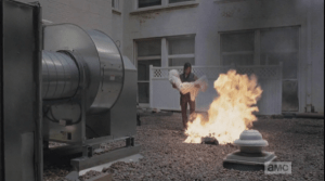 ...Daryl has built a funeral pyre and is carrying the child's shrouded body to the fire...