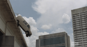 The van topples over the edge...