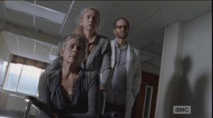 We see Beth wheeling Carol down the hall in a wheelchair, with Doc Edwards behind them.