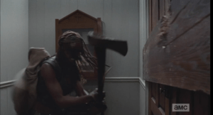 Wearing Baby Judith on her back, Michonne looks like the most badass momma ever, chopping at the boarded up church doors with an axe...babywearing, zombie-apocalypse style!