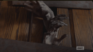 Once outside the church, Michonne quickly closes the doors on the walkers, boarding them closed...and fickle fate once again plays her cruel hand, as the walkers are now locked inside the church, unable to get out.