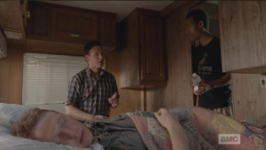 In the back of the RV, while Eric sleeps, Aaron watches over him. Noah comes in with a bottle of water and a bottle of pills. Aaron says he wants to let Eric sleep, but Noah says the pills are for Aaron, as he knows that his hands must be hurting.