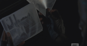 Michonne reaches for the envelope, looks at the pictures of a charming wrap-around porch that boasts a fabulous view of the wall and bracings.