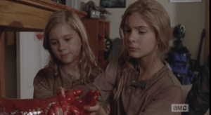 Lizzie and Mika gently reach out and take Tyreese's arm, looking at the blood with quiet concern, but not fear. The look up at him, and gently begin to pull at the arm...