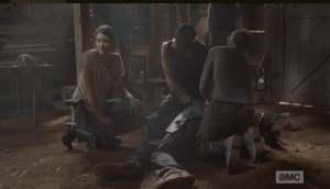 Maggie, kneeling beside Aaron's unconscious form, turns and gently tries to chime in the voice of reason.