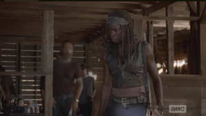 Michonne steps forward, in a role reversal with Rick, who hangs back, and interrupts Aaron.