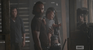 As the barn door is closed behind him, Aaron looks nervously, in thanks, towards Maggie, and then towards Rick and the group, who stand and face him silently, weapons drawn.