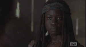 Michonne's face, and manner, become firm, no-nonsense.