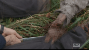 Aaron chops the walker's hand away, and Daryl comes forward and stomps the walker's head.