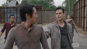 Aidan charges up behind Glenn, reaches out and stops him,