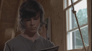 Carl picks up a comic and starts reading.
