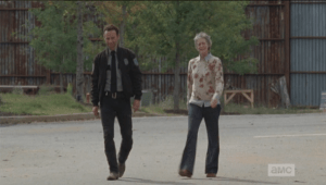 Carol excuses herself, seeing Rick, telling the other JL ladies that she needs to ask him for his help with the party. As they walk together, Rick and Carol agree that tonight would be the night to break into the armory, as everyone will be at the party.