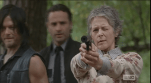 Carol, however, motions to the men...she's got this. She points her gun and starts shooting at the approaching walker.