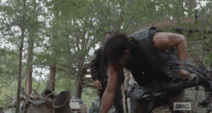 Daryl sees something on the walker's forehead, bends over for a closer look.