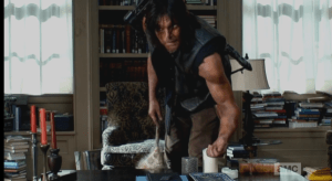 Daryl is leaned over, fiddling with some polished stones, or dice, or something on Deanna's desk. We hear Deanna's voice, through the recorder,