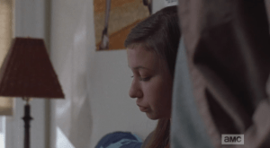 While Mikey gets up to greet Carl, Enid doesn't look up from what she's reading.