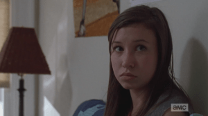 Enid looks up at Carl, seemingly identifying with his shellshock, as she has experienced the horrors of the world outside the walls, herself. She must know how weird it feels to be planted into this surreal suburban reality after experiencing what she and Carl have, outside.