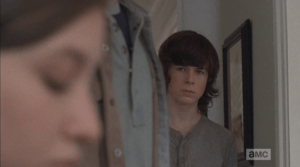 Rowan goes over and puts a hand on Enid's shoulder. Must be her self-appointed boyfriend...she does have the spot on his bed. As Carl shyly sneaks a look over at Enid, Rowan explains that Enid's from the