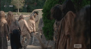 Eugene leads the walkers outside away from the doors.