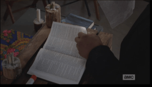 Gabrielsteps up to his place at the altar, and begins to leaf through the pages of the bible which is placed, open and waiting, for Alexandria's new priest.