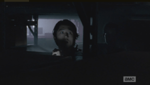 Hearing shots, Glenn shines his flashlight over the shelving and sees the armored walker approaching Aiden. Glenn advises Aiden to let the armored walker get closer before trying to rekill it.