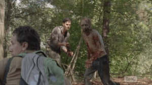 Noah raises his pistol, but Nicholas waves him down, and Aidan is actually trying to chain the walker's rotting hands behind its rotting back, again. Totally stupid.
