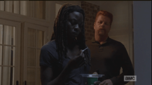 Abraham comes up behind her, quips,