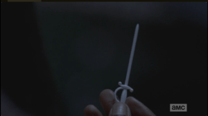 She studies the plastic cocktail sword in her hand.