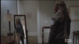 Meanwhile, Michonne models her new constable's uniform in the mirror.
