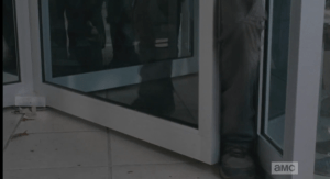 ...and pushes his foot through the opening of the door...