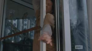 Not heeding Glenn, Nicholas squeezes an arm through, trying to press through and free himself at any cost.