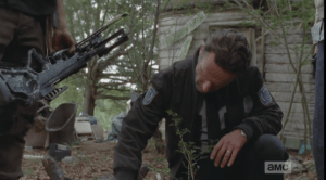 Rick kneels over the walker, studies it a long moment...surely he must remember those walker heads and upper torsos that fell on the van's hood back at the Shirewilt Estates, 100 miles away...those walkers' foreheads, too, were clearly marked with