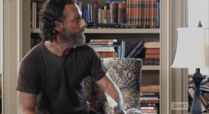 Rather than relaxing into the chair, Rick sits on the edge of it, taking a moment more to look off to the side, at something in the room...