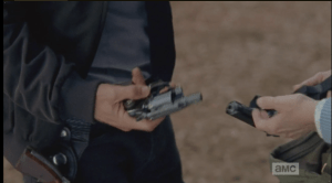 After a moment's hesitation, Rick takes a gun.