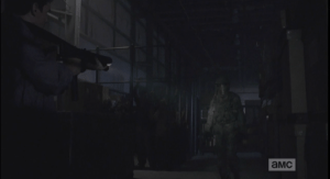 The walker is encased in military-issue full-protective gear, including helmet and face shield.