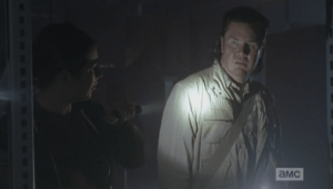 Tara then turns and shines her flashlight on Eugene, who gapes in fear and horror at the trapped walkers...