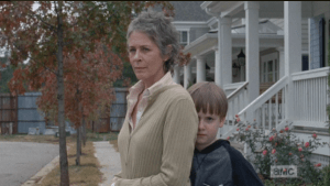 Carol looks at Rick, Sam hiding behind her, like, 
