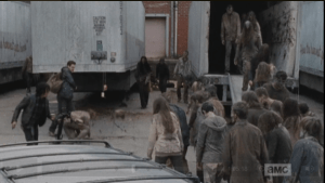 There are too many walkers to fight through, and Aaron and Daryl dive under one of the tractor trailers for momentary cover.