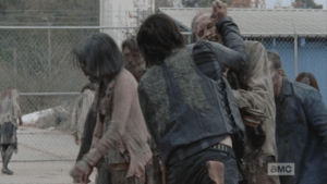 Daryl and Aaron must fight through the first wave of walkers...Daryl uses his knife to spear through the walkers' rotten skulls...