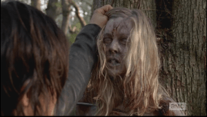 As Daryl holds the young woman's head up, her eyes flutter open as she reanimates.
