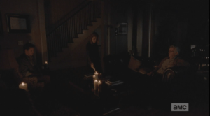 Deanna comes back into her living room with Carol's sympathy note, and holds the note to the candle's flame.