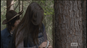 ...then Enid pulls out a white plastic kitchen timer out of her pack. She winds it, then lobs it out so it lands in front of the walker's path...the timer ticks a moment, then the alarm goes off, diverting the walker.