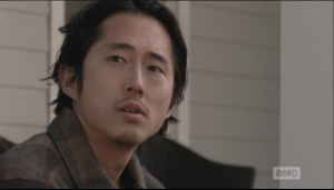 After Maggie leaves, Glenn sits a moment more on the porch, thinking...a sudden noise makes him look up, and he sees...