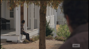 Glenn sits on the porch, waiting for Maggie to return from her meeting with Deanna as a shady lurker watches him from the shadows....